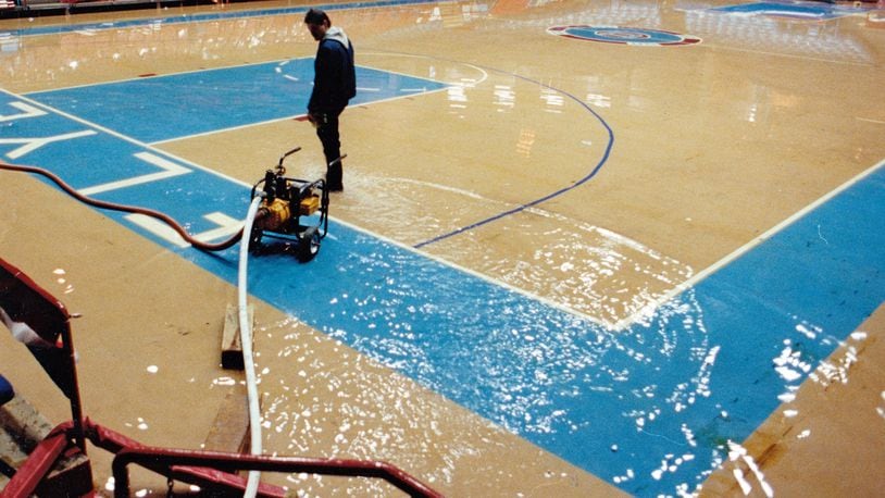Workers us pumps to remove water from the floor of the University of Dayton Arena on January 1, 1991.  WALLY NELSON / DAYTON DAILY NEWS