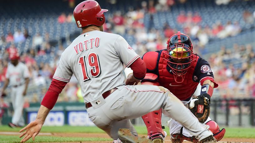 WASHINGTON, DC - AUGUST 12: Joey Votto #19 of the Cincinnati Reds is tagged out at home plate by Kurt Suzuki #28 of the Washington Nationals in the first inning at Nationals Park on August 12, 2019 in Washington, DC. (Photo by Patrick McDermott/Getty Images)