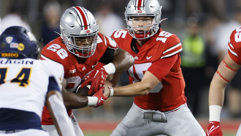 Ohio State quarterback Devin Brown, right, hands off to running back T.C. Caffey during the second half of the team's NCAA college football game against Toledo on Saturday, Sept. 17, 2022, in Columbus, Ohio. (AP Photo/Jay LaPrete)