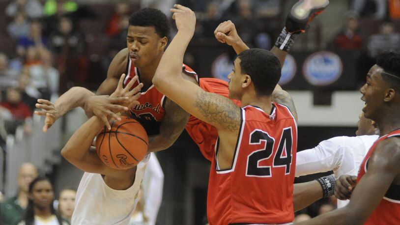Trotwood’s Caleb Johnson (top) goes airborne in joining teammates Torrey Patton (24) and Myles Belyeu in making a defensive stop. Akron St. Vincent-St. Mary defeated Trotwood-Madison 62-60 in a boys high school basketball D-II state semifinal at OSU’s Schottenstein Center in Columbus on Thursday, March 23, 2017. MARC PENDLETON / STAFF