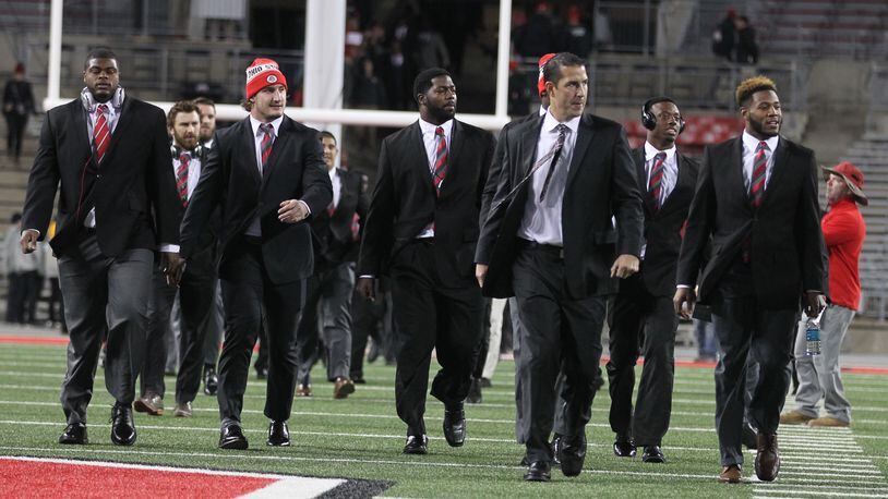 Ohio State defensive coordinator Luke Fickell, second from right, arrives at Ohio Stadium with Buckeye defenders before a game against Minnesota on Saturday, Nov. 7, 2015, in Columbus. David Jablonski/Staff