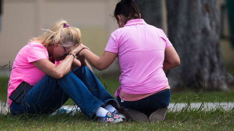 Two women pray outside the family reunification site following a shooting at Santa Fe High School on Friday, May 18, 2018, in Santa Fe, Texas. Ten people were killed and 10 injured in the shooting rampage Friday morning at the school in the southeastern Texas town.