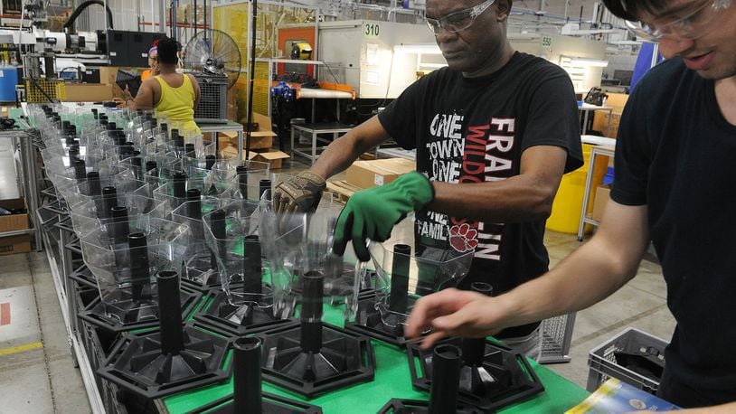 Employees of Innovative Plastic Molders assemble birdfeeders. The company manufactures all the plastic parts in house. MARSHALL GORBY\STAFF