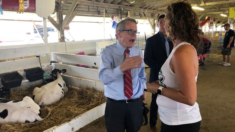 Governor Mike DeWine talks with Clark County Commissioner Melanie Flax-Wilt Monday at the Clark County Fair. DeWine stopped by to see his granddaughter, who was showing her goat at the Fair. BILL LACKEY/STAFF