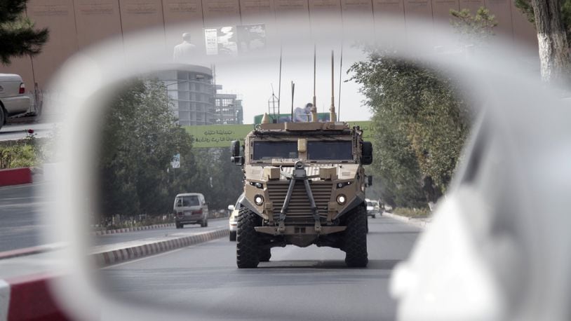 A patrolling U.S. armored vehicle is reflected in the mirror of a car in Kabul, Afghanistan, Wednesday, Aug. 23, 2017. In a national address Monday night, U.S. President Donald Trump reversed his past calls for a speedy exit and recommitted the United States to the 16-year-old conflict, saying U.S. troops must “fight to win.” (AP Photo/Rahmat Gul)
