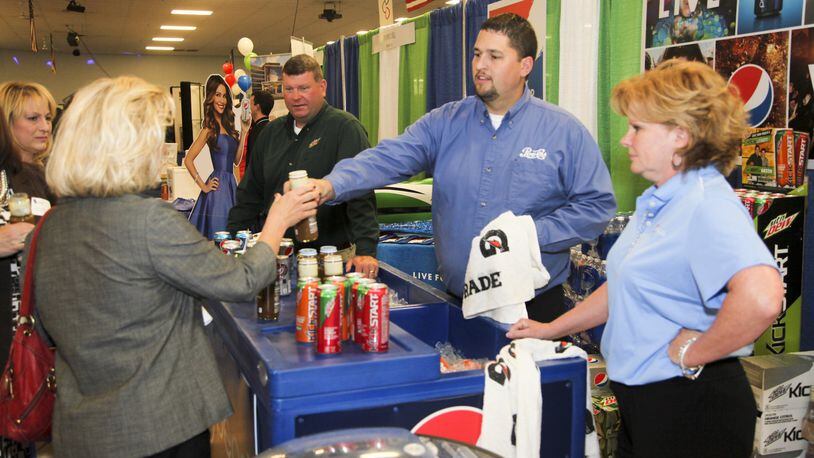 Nick Boggs, Chris Lusk, and Sandy Ratliff of Pepsi, hand out drink samples during a previous West Chester-Liberty Chamber Alliance Regional Business Expo held at Skatetown USA in West Chester Twp. The annual event is preceded by a Taste of West Chester/Liberty luncheon that features Pepsi and more than 40 other dining and beverage vendors. GREG LYNCH / STAFF