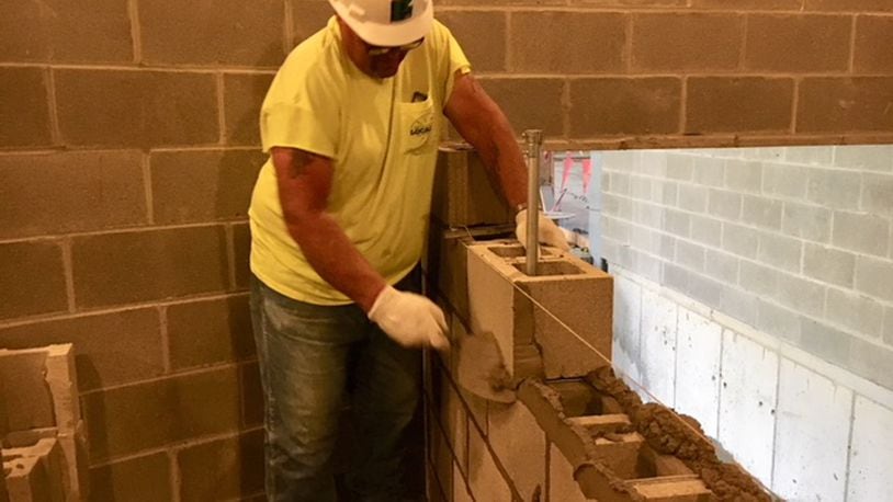 Jerry Carroll, a mason, builds a wall at a Shook-Touchstone construction site at Fairmont High School in this August 2018 file photo. THOMAS GNAU/STAFF