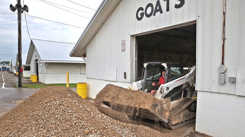 A work crew at the Clark County Fairgrounds puts down new gravel for the floor of the Goat Barn Friday as they get ready for the upcoming fair. BILL LACKEY/STAFF