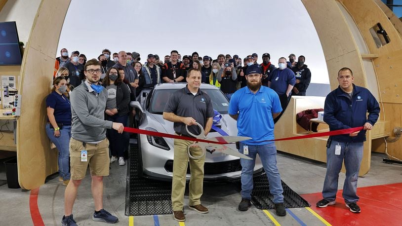 Carvana, an automotive processing facility at 5506 Kennel Road in Trenton, held its ribbon-cutting Friday afternoon. General manager Justin Nelsen holds the scissors while associates stand in a large area when the cars are photographed. NICK GRAHAM/STAFF