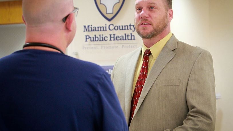 Dennis Propes, right, talks to Dr. Daniel Dilworth in the Miami County Health Department in Troy in this file photo. Propes, the county health commissioner, wants schools to do more to ensure people are wearing masks and practicing social distancing at school and sporting events.  FILE