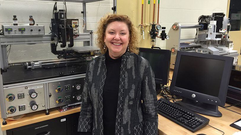 Dr. Katie Thorp, then chief of the Soft Matter Materials Branch, Materials and Manufacturing Directorate, Air Force Research Laboratory, stands in front of a printer that can use conductive, multi-purpose inks in this photo taken in March 2015. Thorp had fought cancer since 1994 and had trained as a resilience training assistant to pass along knowledge she had gained in her own personal battle with cancer. Thorp passed away in July 2018, just one day after learning about winning the Society of Women Engineers PRISM Award. (Skywrighter photo/Amy Rollins)