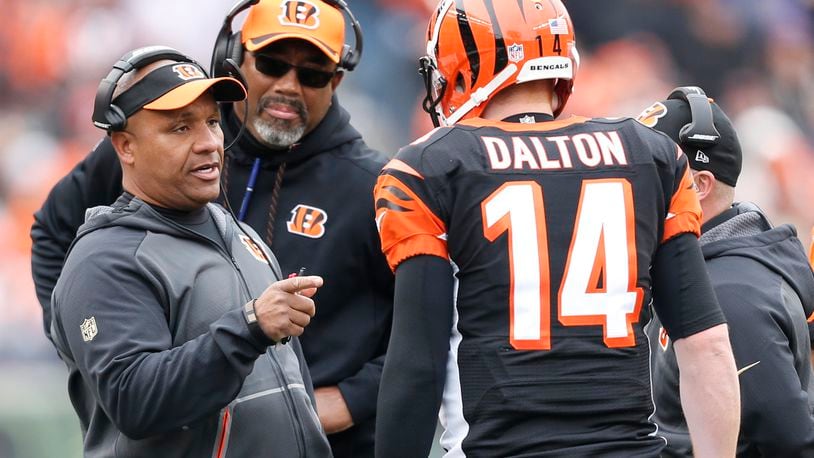 Cincinnati Bengals offensive coordinator Hue Jackson speaks with quarterback Andy Dalton (14) in the first half of an NFL football game against the St. Louis Rams, Sunday, Nov. 29, 2015, in Cincinnati. (AP Photo/Frank Victores)