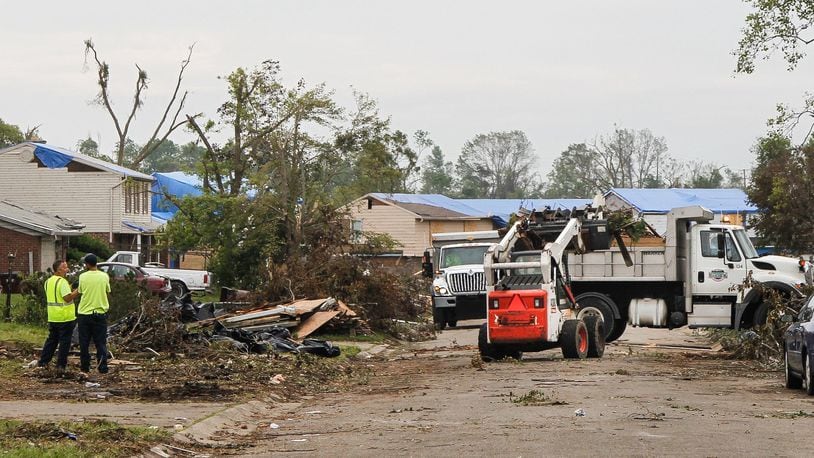 Workers continued to clear tornado debris along Olive Tree Drive in Trotwood on Wednesday. CHRIS STEWART / STAFF