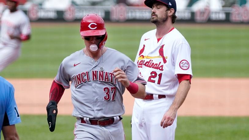 Cincinnati Reds' Tyler Stephenson, left, scores on a wild pitch by St. Louis Cardinals relief pitcher Andrew Miller, right, during the seventh inning of a baseball game Sunday, Sept. 13, 2020, in St. Louis. (AP Photo/Jeff Roberson)