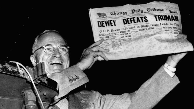 President Harry S. Truman gleefully displays a premature early edition of the Chicago Daily Tribune from his train in St. Louis, Missouri, after his defeat of Thomas E. Dewey in the 1948 presidential election.
