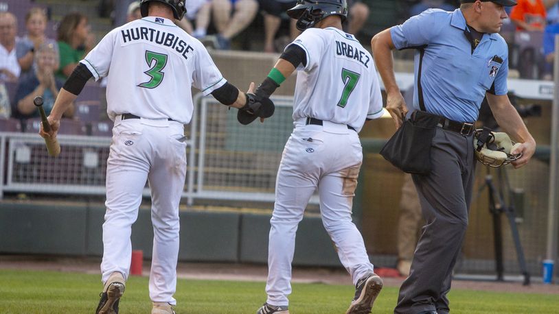 Jacob Hurtibise and Francisco Urbaez head to the dugout after scoring on Juan Martinez's double in the third inning Thursday night at Day Air Ballpark. Jeff Gilbert/CONTRIBUTED