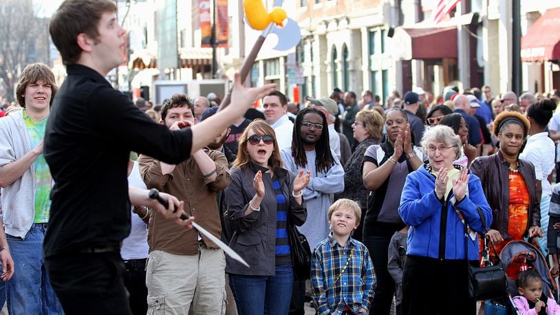 E.L. Hubbard photography People watch a street performer during the NCAA First Four Festival in downtown Dayton's Oregon District Sunday, March 11, 2012. Big Hoopla, a volunteer based non-profit that organizes local activities around the NCAA First Four and the Division I Men’s Basketball Tournament held at the University of Dayton, and the Oregon District Business Association will hold a family-friendly festival 10 a.m. to 8 p.m. March 15, 2020.