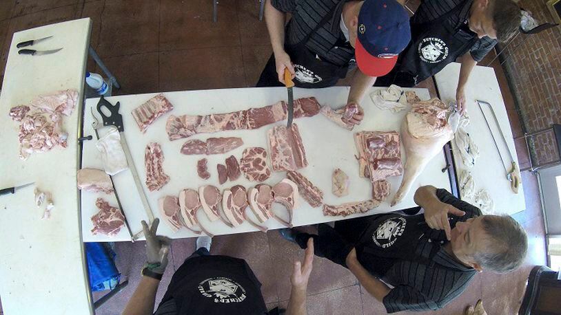 Dany Johnson, bottom right, talks to members of Team USA for the World Butchers' Challenge 2018 that will be held in Belfast, Ireland as they work on a pork during a practice run at Taylor's Meat Market on Monday, Aug. 7, 2017. (Hector Amezcua/Sacramento Bee/TNS)