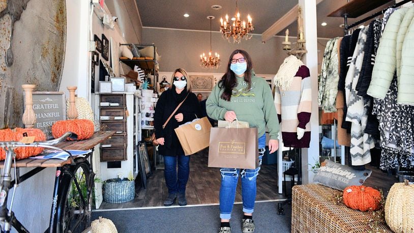 Shoppers leave Fox and Feather in downtown Tipp City during the annual Yuletide Winter's Gathering activities. Business supporters throughout the region are encouraging shopping local to assist businesses that have had a tough year thanks to COVID-19.