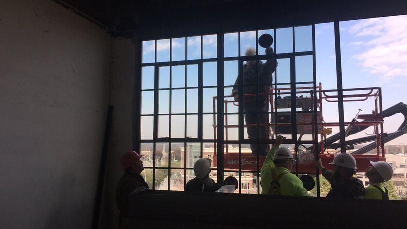 Crews install windows at the former Delco building, which is being converted into lofts and restaurant space. MIKE HOYING /BRACKETT BUILDERS