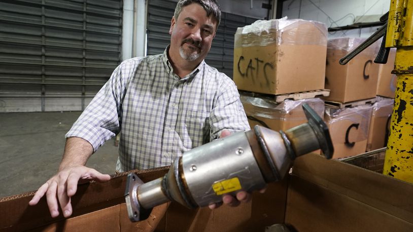 Troy Webber, owner of Chesterfield Auto Parts, holds a used catalytic converter that was removed from one of the cars at his salvage yard Friday Dec. 17, 2021, in Richmond, Va. Thefts of the emission control devices have jumped over the last two years as prices for the precious metals they contain have skyrocketed. (AP Photo/Steve Helber)