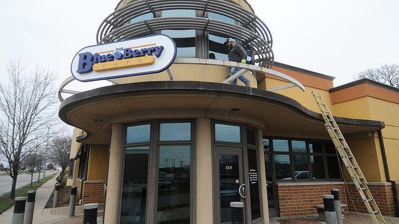 Marc Robinson of Wilcon Construction places The Blue Berry Cafe sign on the old Golden Nuggent Pancake House in Kettering Wednesday, Jan. 3, 2024. MARSHALL GORBY\STAFF