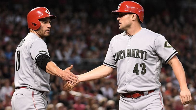 PHOENIX, AZ - MAY 28: Scott Schebler #43 of the Cincinnati Reds is congratulated by Joey Votto #19 after scoring against the Arizona Diamondbacks in the fifth inning of the MLB game at Chase Field on May 28, 2018 in Phoenix, Arizona. MLB players across the league are wearing special uniforms to commemorate Memorial Day. (Photo by Jennifer Stewart/Getty Images)