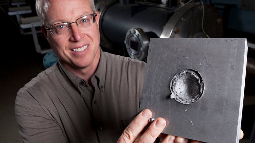 The University of Dayton is among the top three universities in the nation when it comes to sponsored materials research, the university said Tuesday. UD Research Institute senior impact physics engineer Kevin Poormon displays an aluminum block that was struck by a projectile sphere like the one between his fingers in this 2014 photo. TY GREENLEES / STAFF