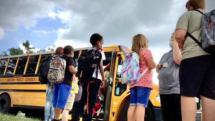 Students wait to get on the school bus at Eastmont elementary school Wednesday Aug. 18, 2021 in Dayton. MARSHALL GORBY\STAFF