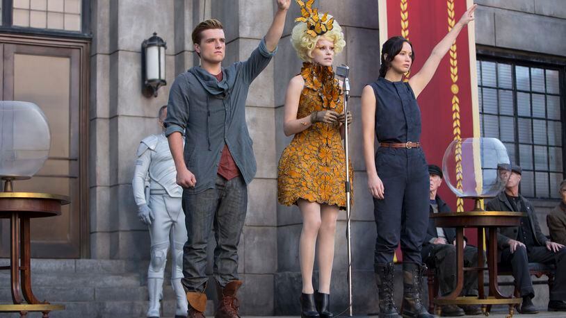 Katniss Everdeen (Jennifer Lawrence, right), Effie Trinket (Elizabeth Banks, center) and Peeta Mellark (Josh Hutcherson, left) in “The Hunger Games: Catching Fire.” Photo Credit: Murray Close