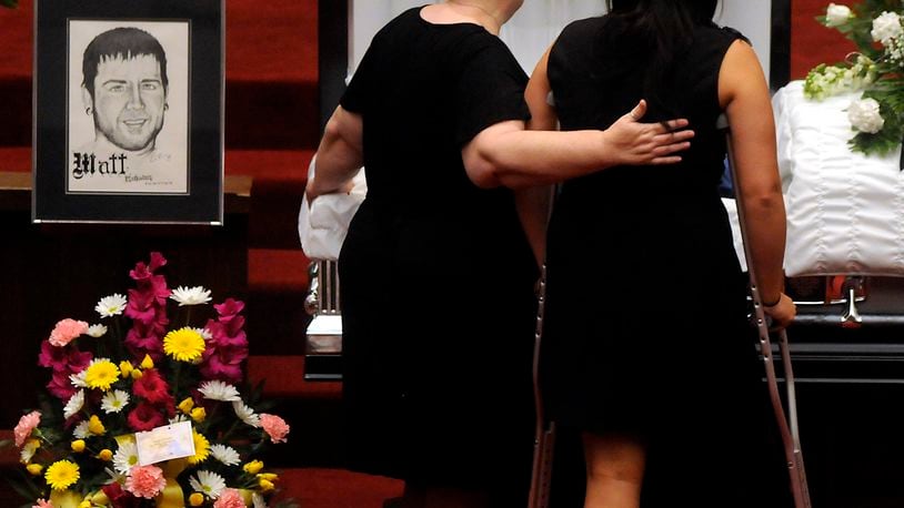 Samantha Yowler, right, pays her final respects to boyfriend Matt McQuinn, who died protecting her during a shooting that left 12 dead and 58 wounded July 20 in Aurora, Colo. The service was Saturday in Springfield's Maiden Lane Church of God. Staff photo by Marshall Gorby