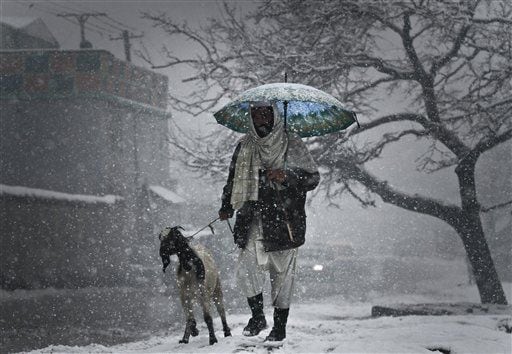 An Afghan man walks with his goat in Kabul, Afghanistan.