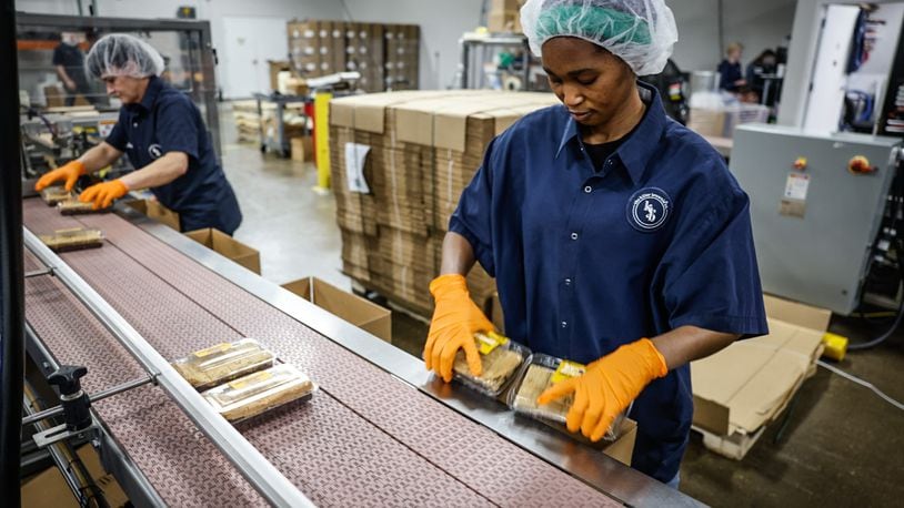 Killer Brownie packing team member Juhuei Eudia packages-up killer brownies at the Miamisburg plant. JIM NOELKER/STAFF