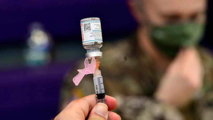 Spc. Brady McNeil, a radiologist with the Vermont Army National Guard, draws up a dose of the Moderna COVID-19 during a vaccination clinic at the Brattleboro Area Middle School, April 14, 2021, in Brattleboro, Vt.   (Kristopher Radder/The Brattleboro Reformer via AP, File)