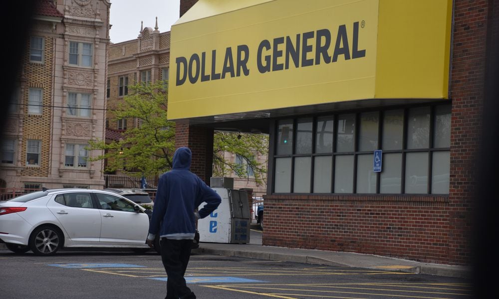 A pedestrian walks through the parking lot of the Dollar General at 445 Salem Ave. in northwest Dayton. CORNELIUS FROLIK / STAFF