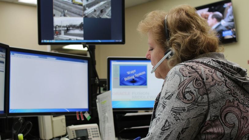 In this photo from 2016, an administrative typist answers calls about water and sewer issues at the city of Dayton’s Water Utility Field Operations dispatch center. CORNELIUS FROLIK / STAFF