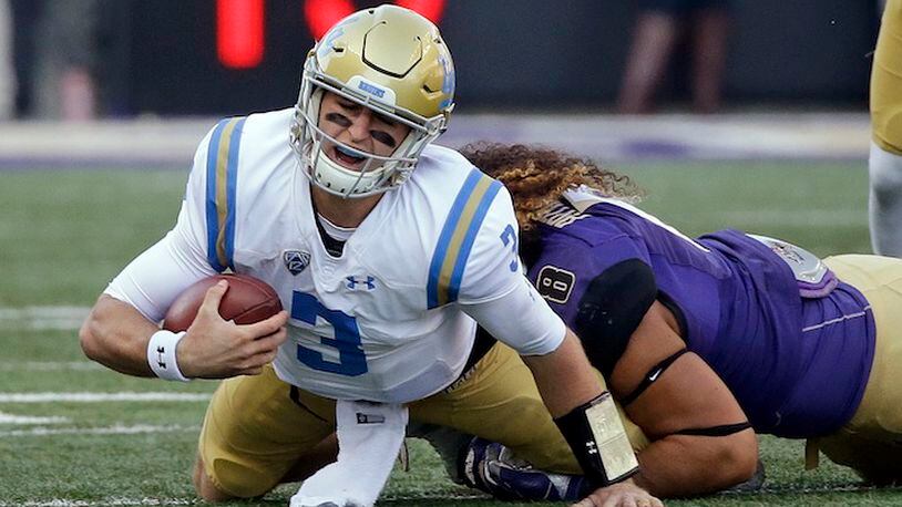 FILE - In this Oct. 28, 2017, file photo, UCLA quarterback Josh Rosen (3) is sacked by Washington's Benning Potoa'e late in the first half of an NCAA college football game, in Seattle. Rosen is being asked to carry a mediocre UCLA team and it seems to be taking a toll. The junior has three touchdown passes and three interceptions in his last three games and has not cracked 60 percent in completions in any of those games. (AP Photo/Elaine Thompson, File)