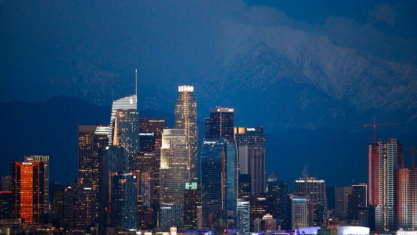 Snow-capped mountains are seen behind the Los Angeles' downtown skyline at dusk Thursday, Feb. 21, 2019, in Los Angeles.