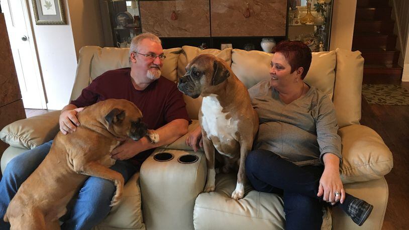 Don and Lisa Gose, of Middletown, sit with two of their three dogs, Zorro and Max. The Gose’s worry how they will continue to pay for Lisa’s medication, one of the most expensive specialty drugs in the world, in the future. KATIE WEDELL/STAFF