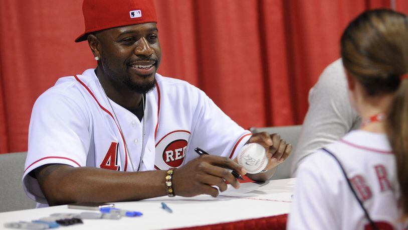 Second baseman Brandon Phillips signs a ball for a young fan at the 2011 Redsfest. CONTRIBUTED