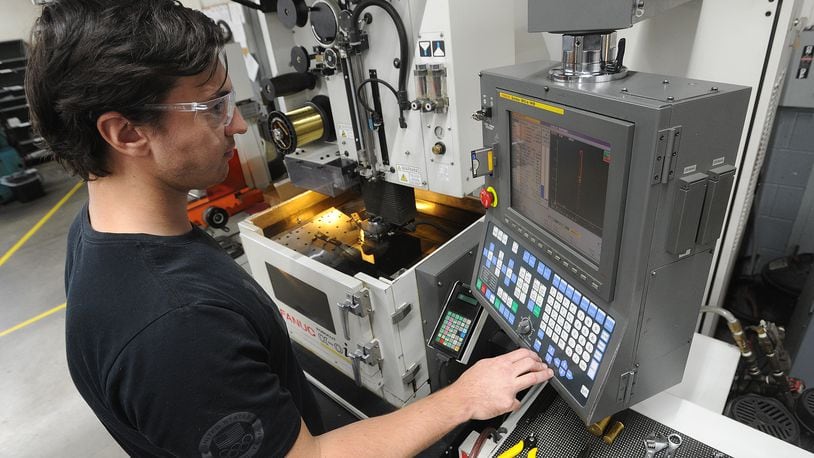 Matt Vanderbrock, a Wire EDM Programmer, runs one of many high tech machines at Noble Tool in Dayton. MARSHALL GORBY\STAFF