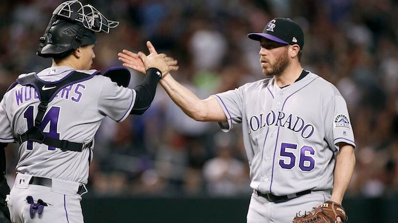 Colorado Rockies' Greg Holland (56) is congratulated by Tony Wolters after pitching the ninth inning against the Arizona Diamondbacks during a baseball game, Saturday, April 29, 2017, in Phoenix. The Rockies won 7-6. (AP Photo/Ralph Freso)