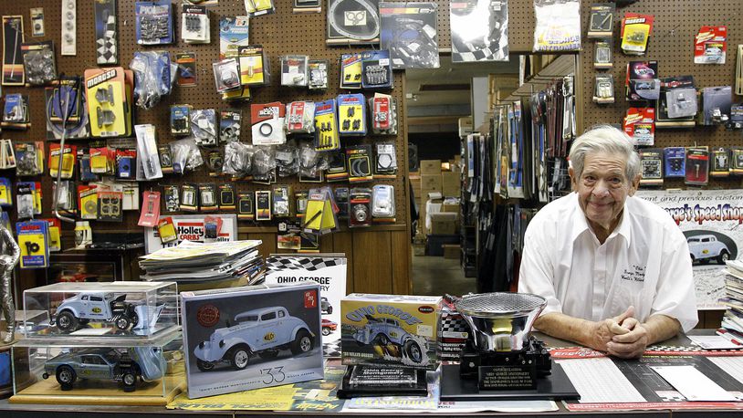 "Ohio" George Montgomery leans on the counter at his speed shop in Dayton. On the left are model car kits of his 1933 Willys Gasser. 

 Oct. 21, 2019
© 2019 Photograph by Skip Peterson
