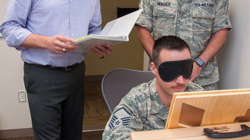 John Heaton (left), Neuropsychiatry Branch manager of the Aeromedical Consultation Service, and Lt. Col. Kevin Heacock, ACS Neuropsychiatry Branch chief, oversee a demonstration of a psychological test on Master Sgt. Walter Croft, the branch’s NCOIC and mental health technician. The test is one of several that are administered to waiver candidates to evaluate cognitive functioning. (The test is not revealed here in order to not compromise its effectiveness in the future). (U.S. Air Force photo/John Harrington)