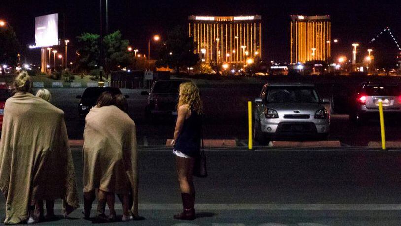 A group of women wait for their ride outside the Thomas & Mack center, which served as a refuge, following a mass shooting at the Route 91 music festival along the Las Vegas Strip, Monday, Oct. 2, 2017, in Las Vegas. (Yasmina Chavez/Las Vegas Sun via AP)
