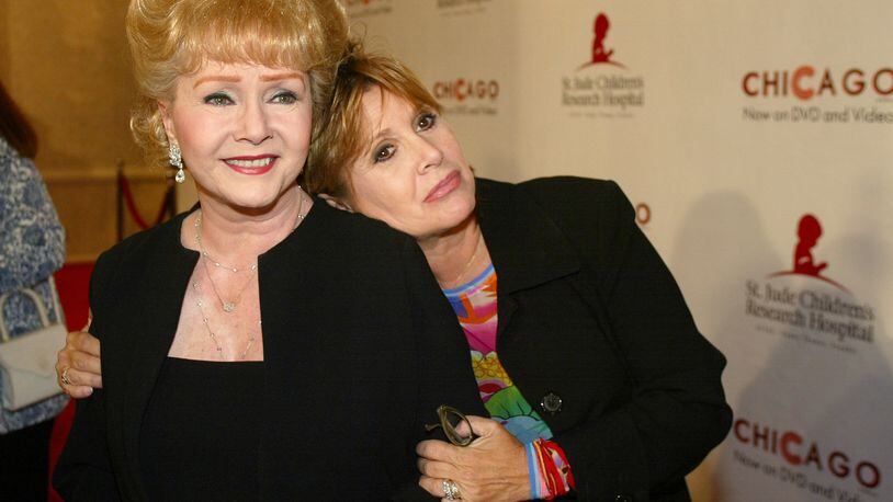 FILE - In this Tuesday, Aug. 19, 2003 file photo, Debbie Reynolds and Carrie Fisher arrive at the "Runway for Life" Celebrity Fashion Show Benefitting St. Jude's Children's Research Hospital and celebrating the DVD relese of Chicago in Beverly Hills, Calif. On Tuesday, Dec. 27, 2016, a publicist said Fisher has died at the age of 60. (AP Photo/Jill Connelly, File)
