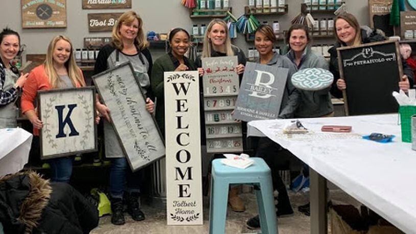 Customers hold up DIY projects that they created at an AR Workshop Centerville event.