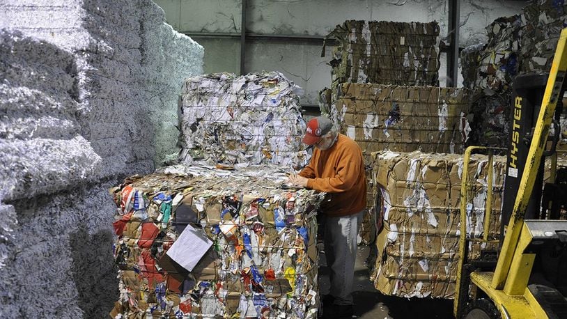 Roger Smart records the tonnage for recycled bales of paper stacked high inside the Base Recycling Center, Bldg. 293, Area A, Wright-Patterson Air Force Base. (U.S. Air Force photo/W. Eugene Barnett Jr.)