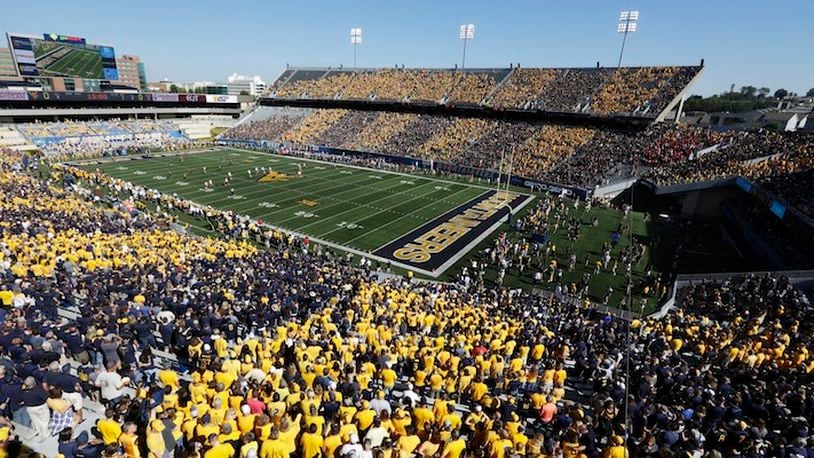FILE - In this Saturday, Oct. 14, 2017, file photo, West Virginia fans stripe the stadium in blue and gold during an NCAA college football game against Texas Tech in Morgantown, W.Va. When a school wants to "stripe" its stadium in school colors, as West Virginia did last week before its game with Texas Tech, school officials merely have to remind fans on Twitter which color to wear based on where they'll be sitting. (AP Photo/Raymond Thompson, File)