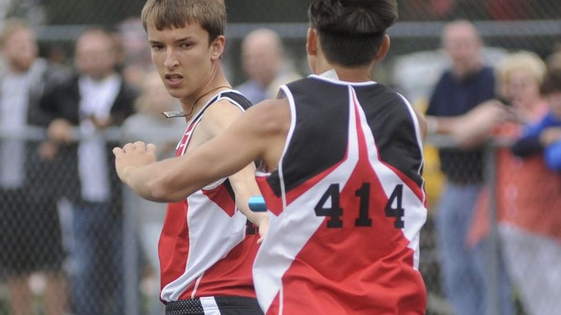 Alan Holdheide of Fort Loramie High School (right) passes the baton to Jake Rethman and the Redskins won the 4x800-meter relay during the D-III regional track and field meet at Troy’s Memorial Stadium on Wednesday, May 24, 2017. MARC PENDLETON / STAFF